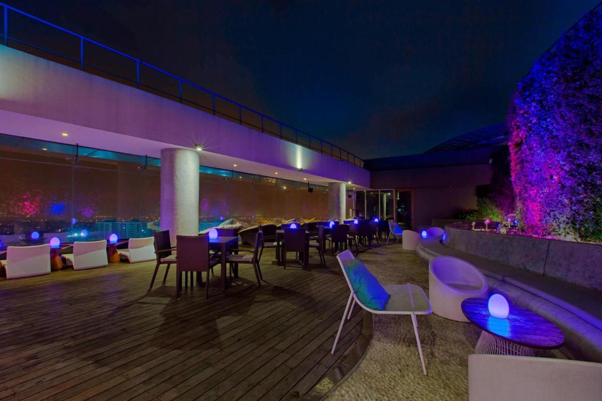 a restaurant with purple and blue lighting and tables and chairs at Sheraton Grand Bangalore Hotel at Brigade Gateway in Bengaluru