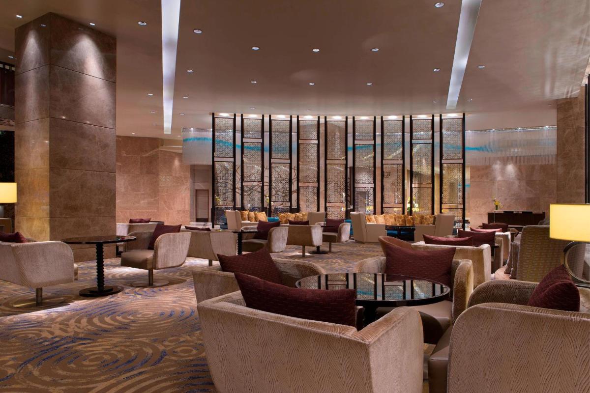 a lobby of a hotel with chairs and tables at Sheraton Grand Bangalore Hotel at Brigade Gateway in Bengaluru