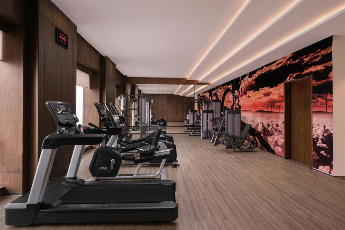 a gym with treadmills and ellipticals in a room at Courtyard by Marriott Amritsar in Amritsar