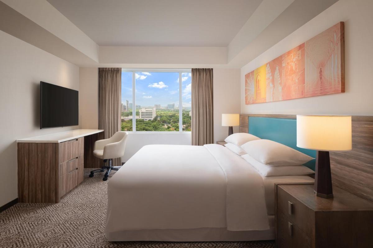 a hotel room with a bed and a television at Sheraton Hyderabad Hotel in Hyderabad