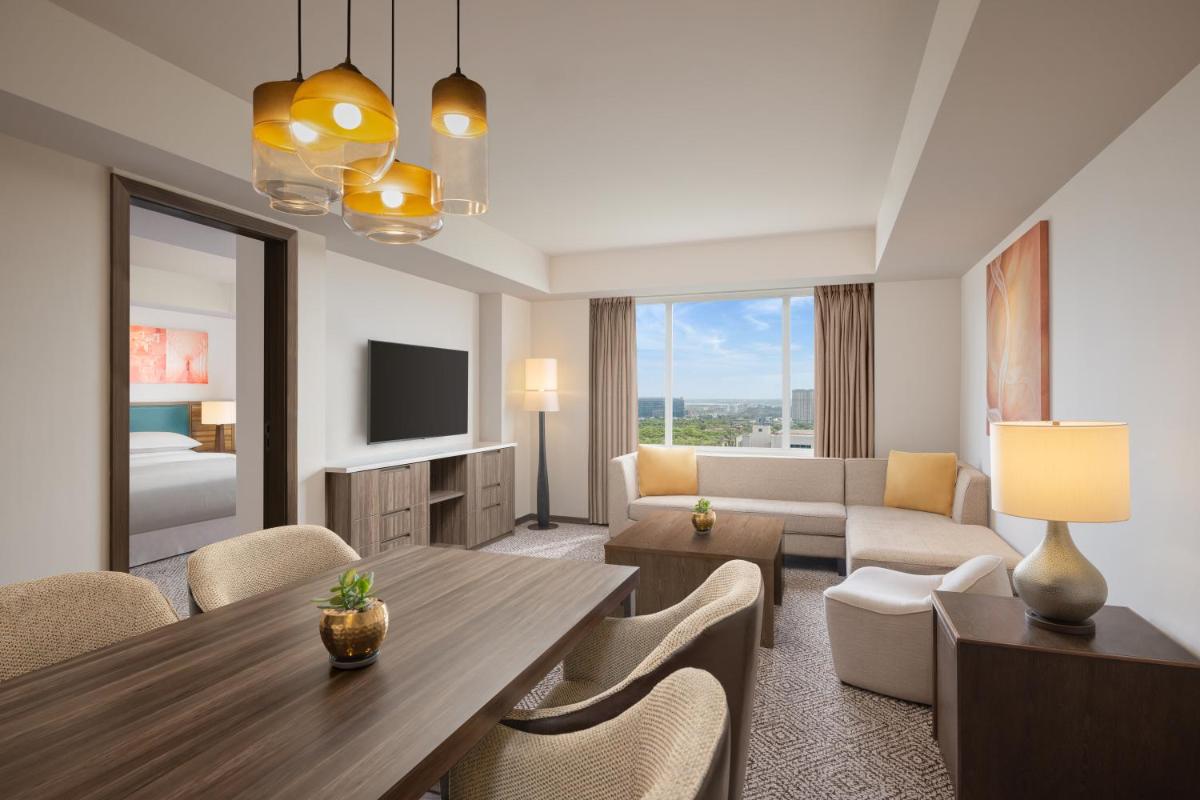 a living room with a dining table and a living room at Sheraton Hyderabad Hotel in Hyderabad a living room with a dining table and a living room at Sheraton Hyderabad Hotel in Hyderabad