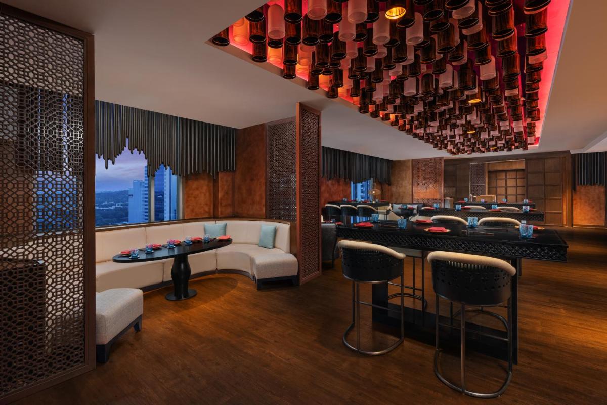 a room with a bar with chairs and wine bottles at Sheraton Hyderabad Hotel in Hyderabad