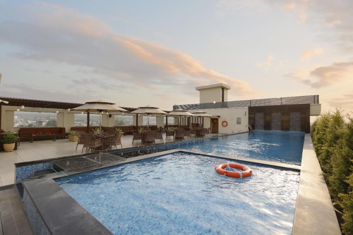 a swimming pool with a raft in the water at Regenta Dehradun by Royal Orchid Hotels Limited in Dehradun