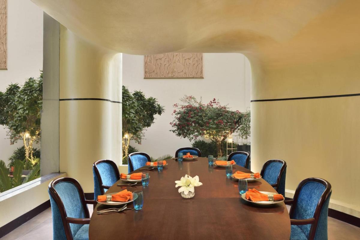 a conference room with a long table and chairs at Jaipur Marriott Hotel in Jaipur a conference room with a long table and chairs at Jaipur Marriott Hotel in Jaipur