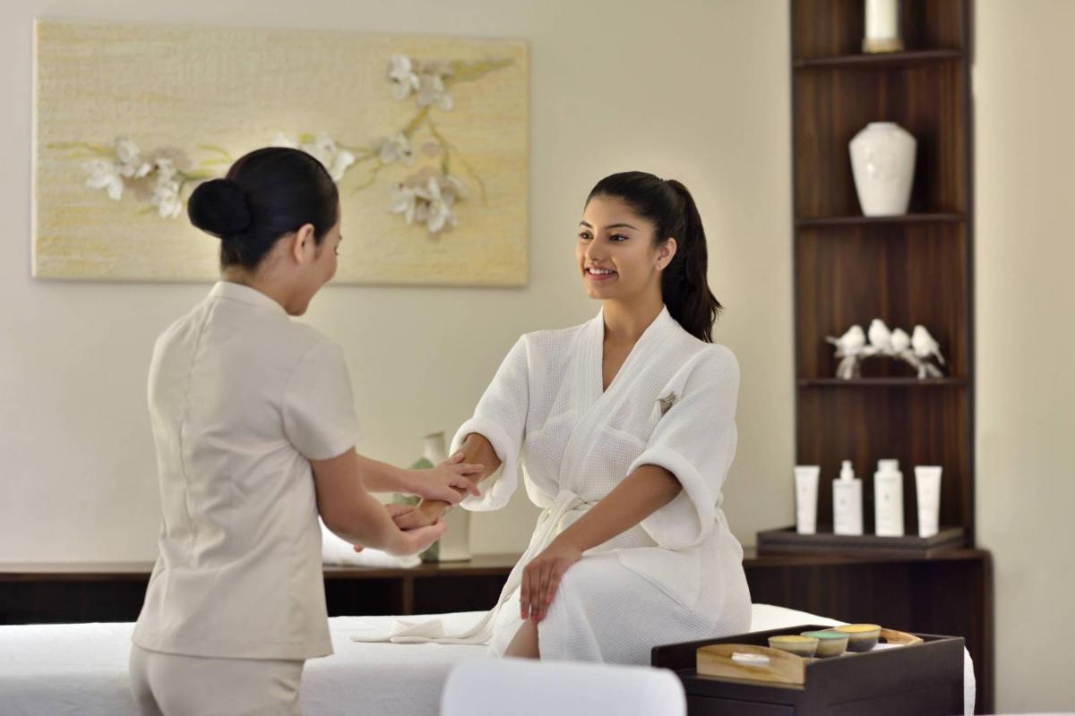 a woman shaking hands with a woman in a hotel room at Jaipur Marriott Hotel in Jaipur a woman shaking hands with a woman in a hotel room at Jaipur Marriott Hotel in Jaipur