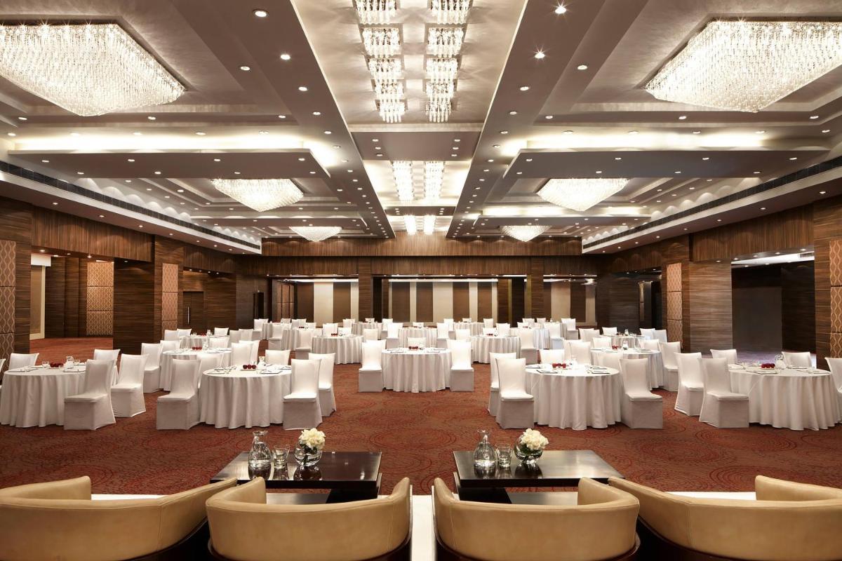 a banquet hall with white tables and chairs at Jaipur Marriott Hotel in Jaipur a banquet hall with white tables and chairs at Jaipur Marriott Hotel in Jaipur
