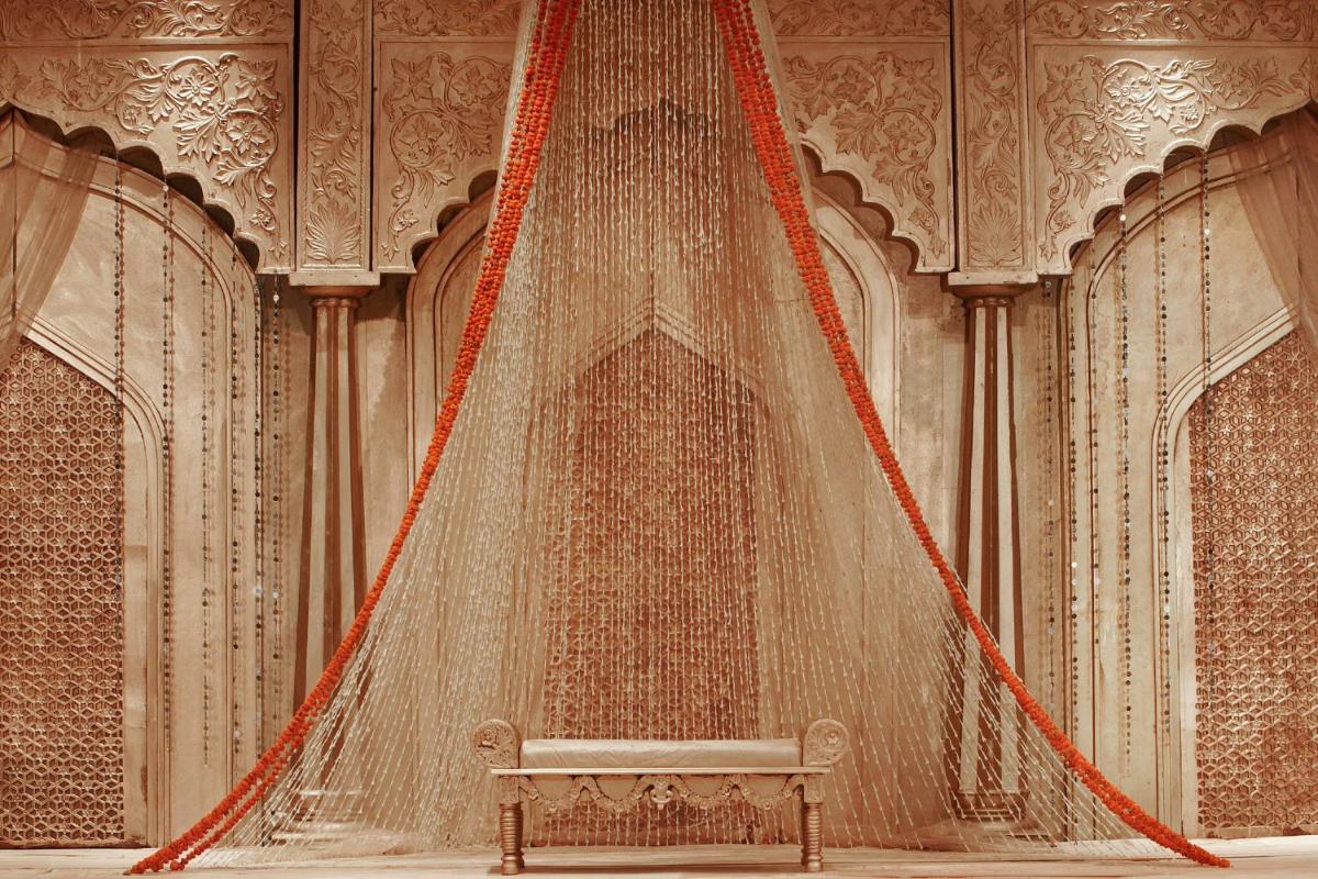 a stage with a bench in a room with curtains at Jaipur Marriott Hotel in Jaipur a stage with a bench in a room with curtains at Jaipur Marriott Hotel in Jaipur