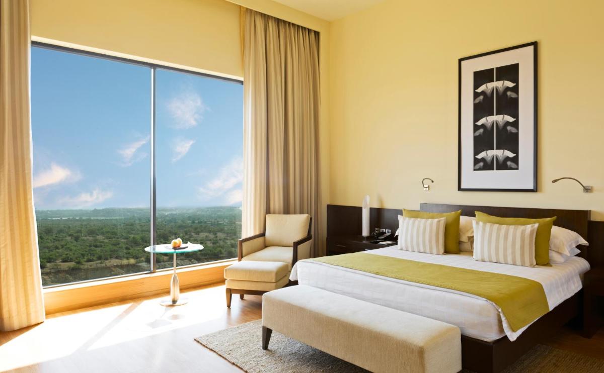 a hotel room with a bed and a large window at Hyatt Hyderabad Gachibowli in Hyderabad