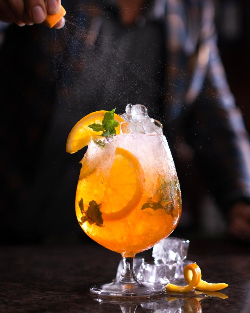 a glass of orange juice with a lemon and mint at Hyatt Place Pune Hinjawadi in Pune