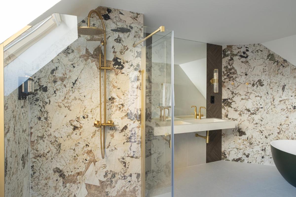 un baño con ducha y lavabo en Eurostars Royal Tanau, en Baqueira Beret un baño con ducha y lavabo en Eurostars Royal Tanau, en Baqueira Beret