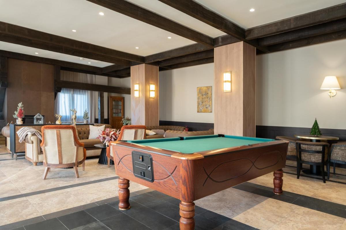 Una sala de estar con una mesa de billar. en Eurostars Royal Tanau, en Baqueira Beret