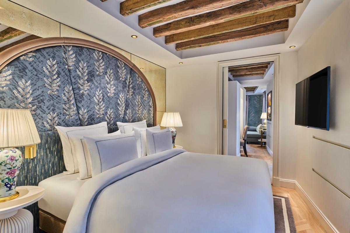 - une chambre avec un grand lit et une télévision dans l'établissement Maison Barrière Vendôme, à Paris