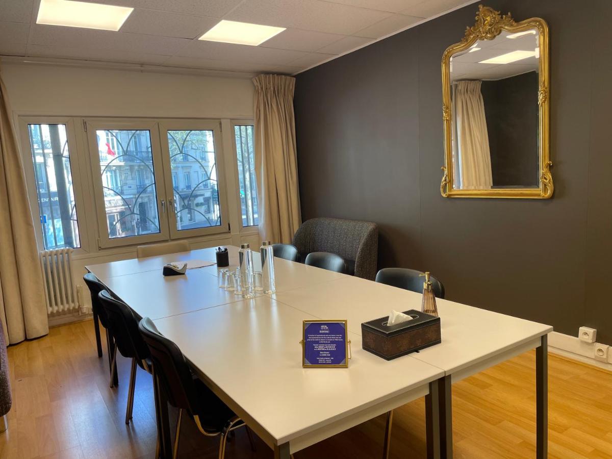 - une salle de réunion avec une table, des chaises et un miroir dans l'établissement Hotel Locomo - Gare de Lyon Bastille, à Paris