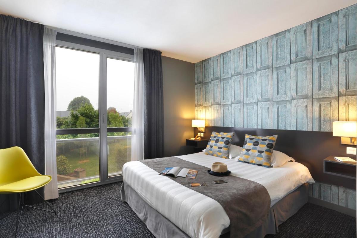 une chambre d'hôtel avec un lit et une grande fenêtre dans l'établissement Altos Hotel & Spa, à Avranches