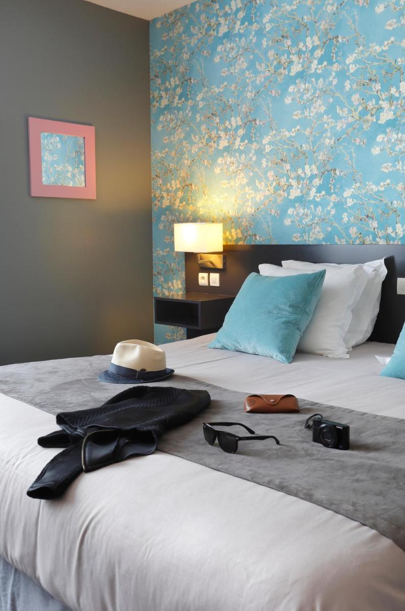 une chambre d'hôtel avec un lit avec des verres et une peinture dans l'établissement Altos Hotel & Spa, à Avranches