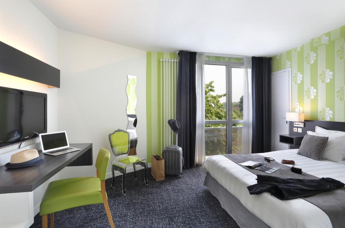 une chambre d'hôtel avec un lit et un bureau avec un ordinateur dans l'établissement Altos Hotel & Spa, à Avranches