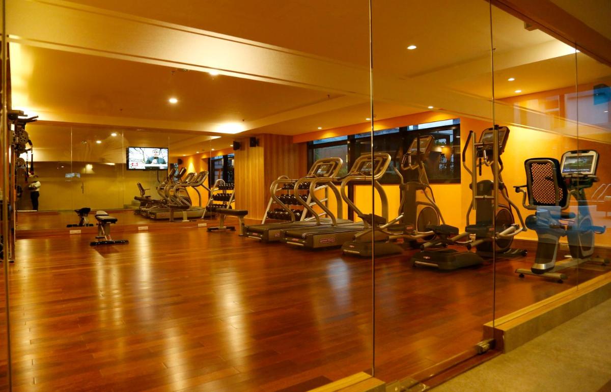 a gym with exercise equipment and a glass wall at The Raviz Calicut in Kozhikode