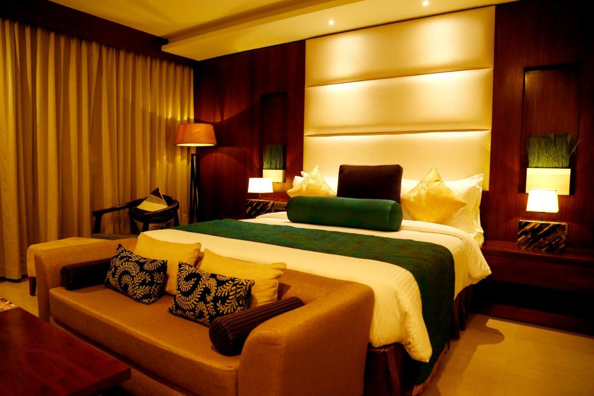 a hotel room with a large bed and a couch at The Raviz Calicut in Kozhikode