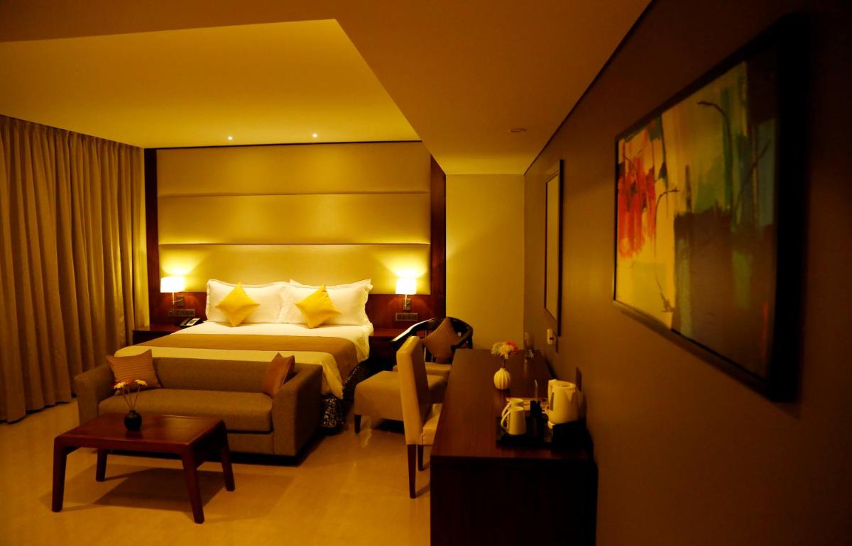 a hotel room with a bed and a couch at The Raviz Calicut in Kozhikode