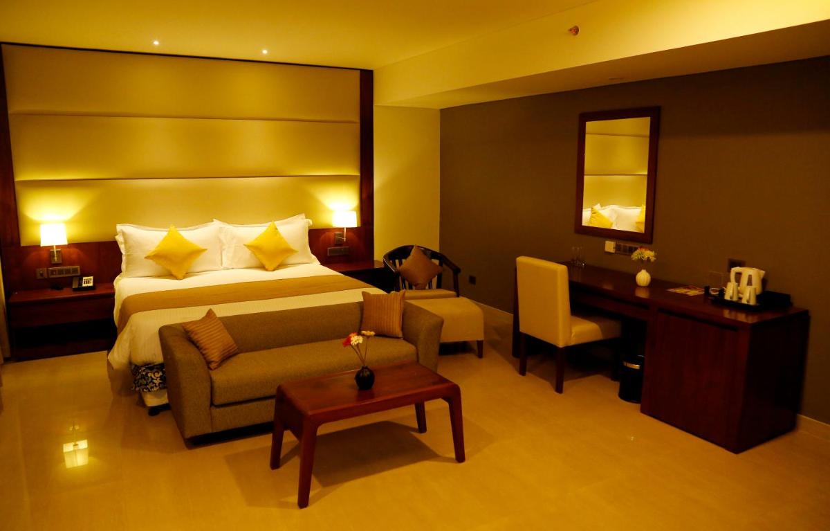a hotel room with a bed and a desk at The Raviz Calicut in Kozhikode