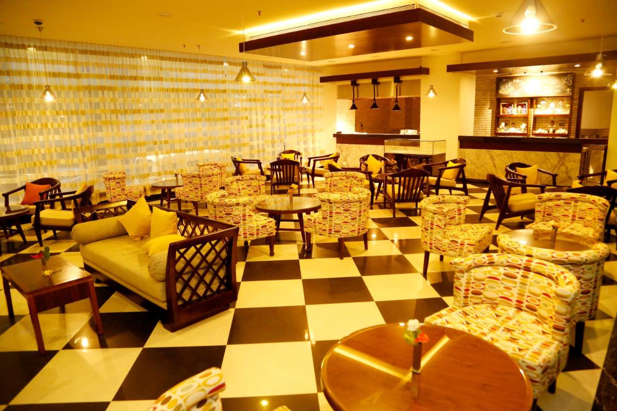 a restaurant with tables and chairs and a checkered floor at The Raviz Calicut in Kozhikode