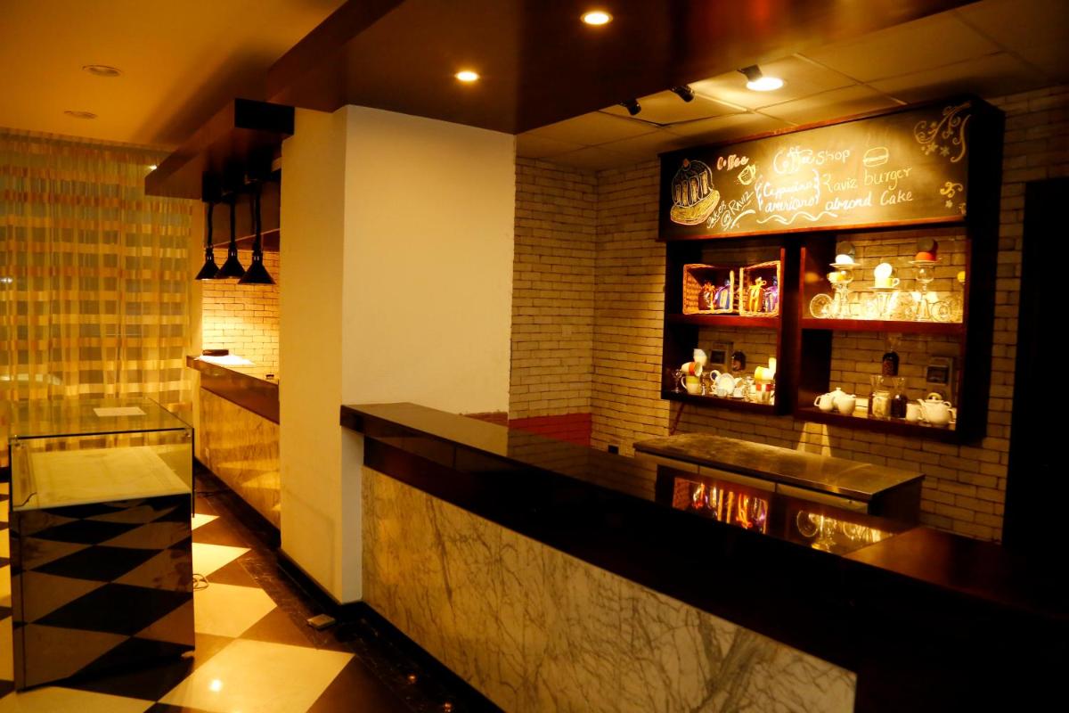a bar in a restaurant with a counter at The Raviz Calicut in Kozhikode
