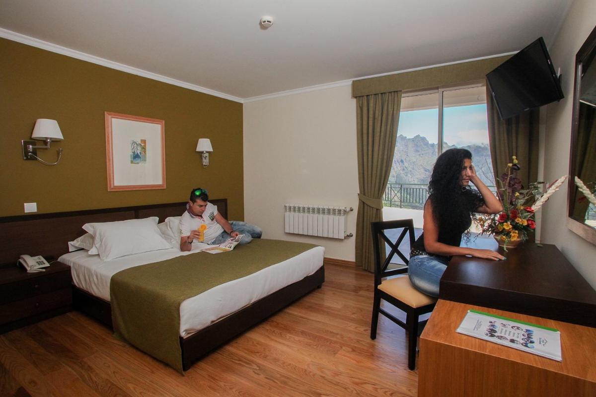 uma mulher e uma criança num quarto de hotel em Eira do Serrado - Hotel & Spa em Curral das Freiras