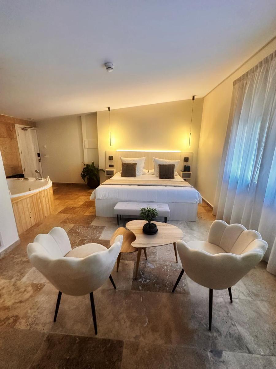 Un dormitorio con una cama y dos sillas y una mesa. en Boutique Hotel Comtal Empuries, en Roses