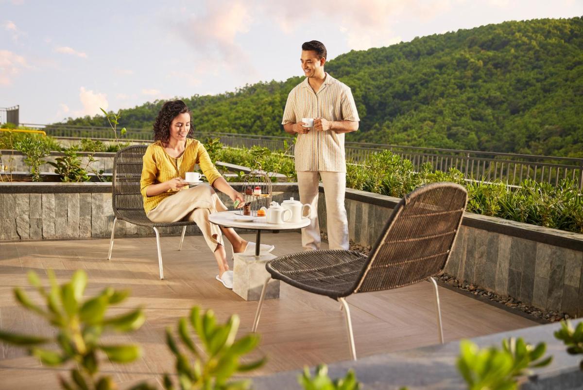 a man and a woman sitting on a roof at Hyatt Regency Dehradun Resort and Spa in Dehradun