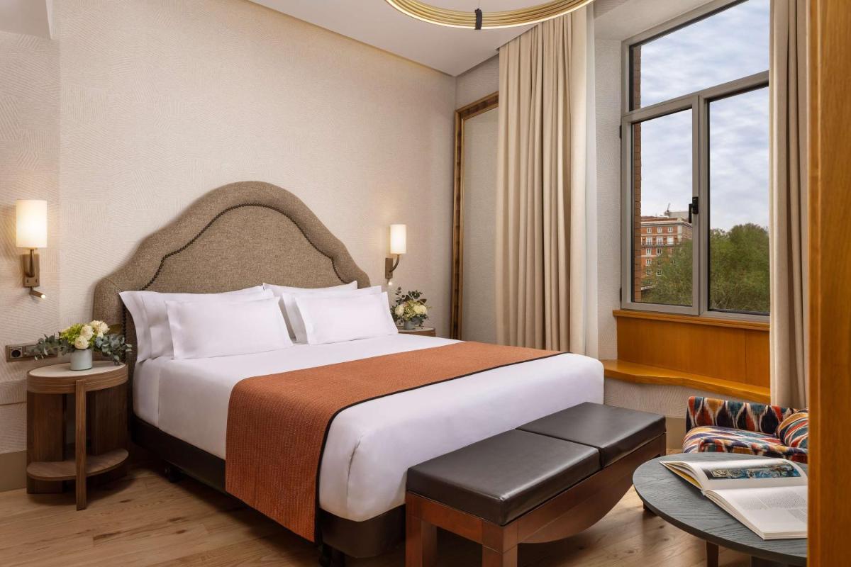 Una habitación de hotel con una cama y una ventana. en NH Collection Madrid Paseo del Prado, en Madrid