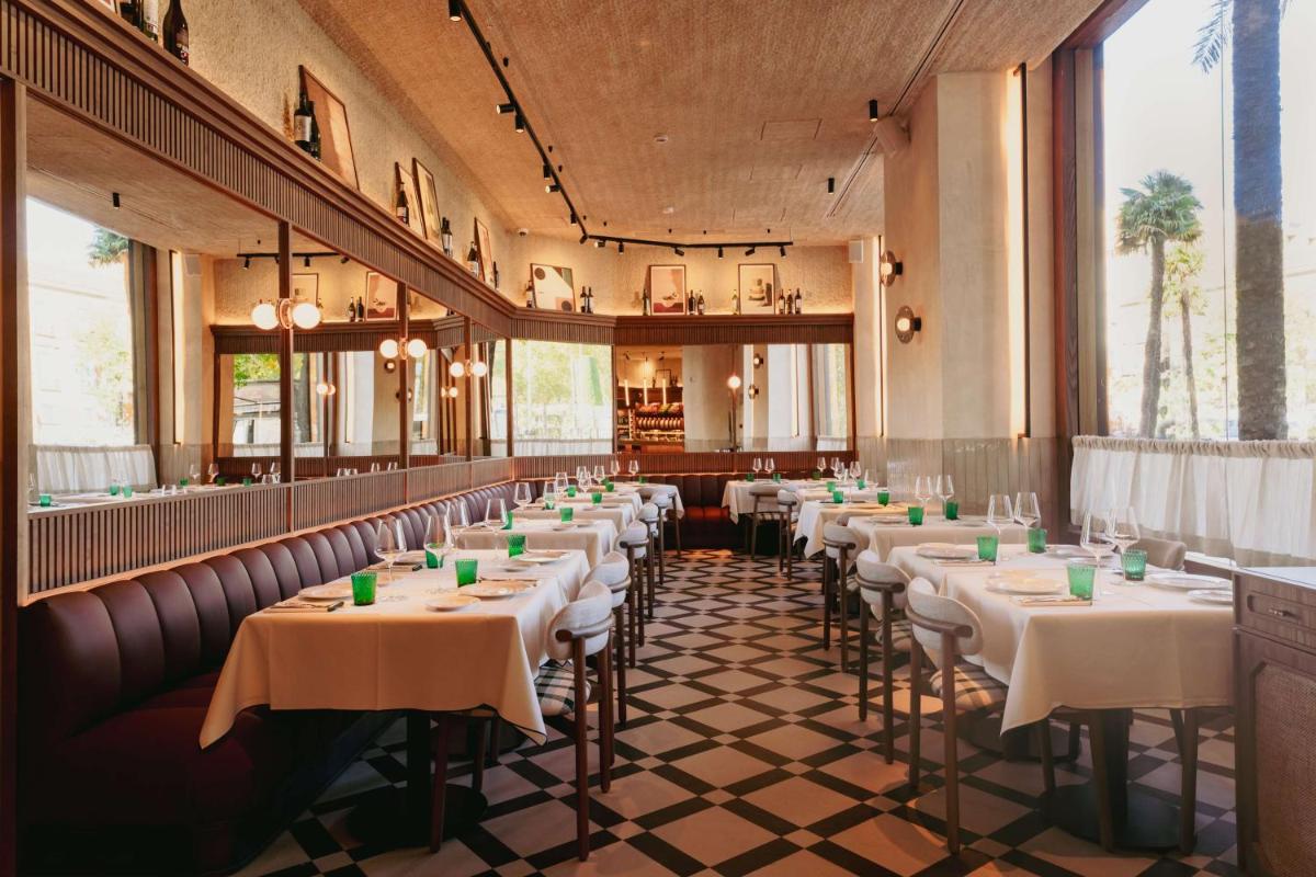 una fila de mesas en un restaurante con mantel blanco en NH Collection Madrid Paseo del Prado, en Madrid