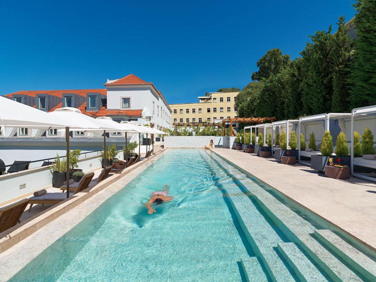 uma pessoa a nadar numa piscina em The One Palácio da Anunciada em Lisboa