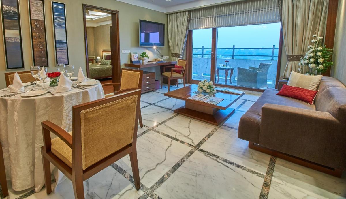 a living room with a couch and a table at Jaypee Vasant Continental in New Delhi