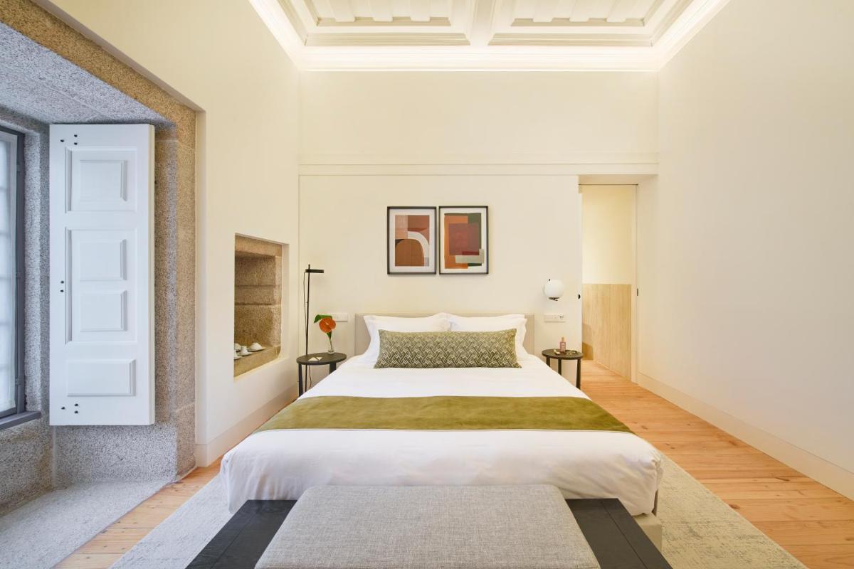 um quarto com uma cama grande em um quarto branco em MS Collection Arouca - Mosteiro de Arouca em Arouca