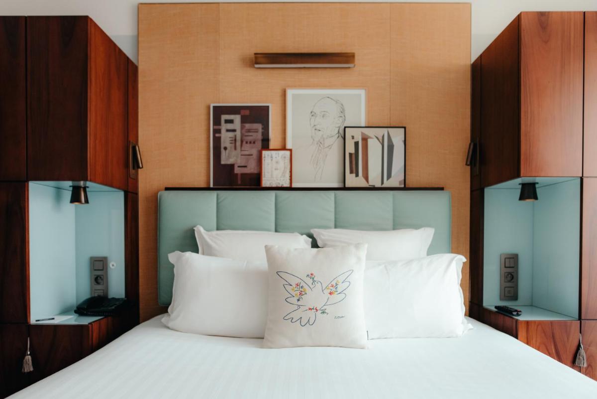 une chambre avec un grand lit avec des oreillers blancs dans l'établissement Hotel Eiffel Blomet, à Paris