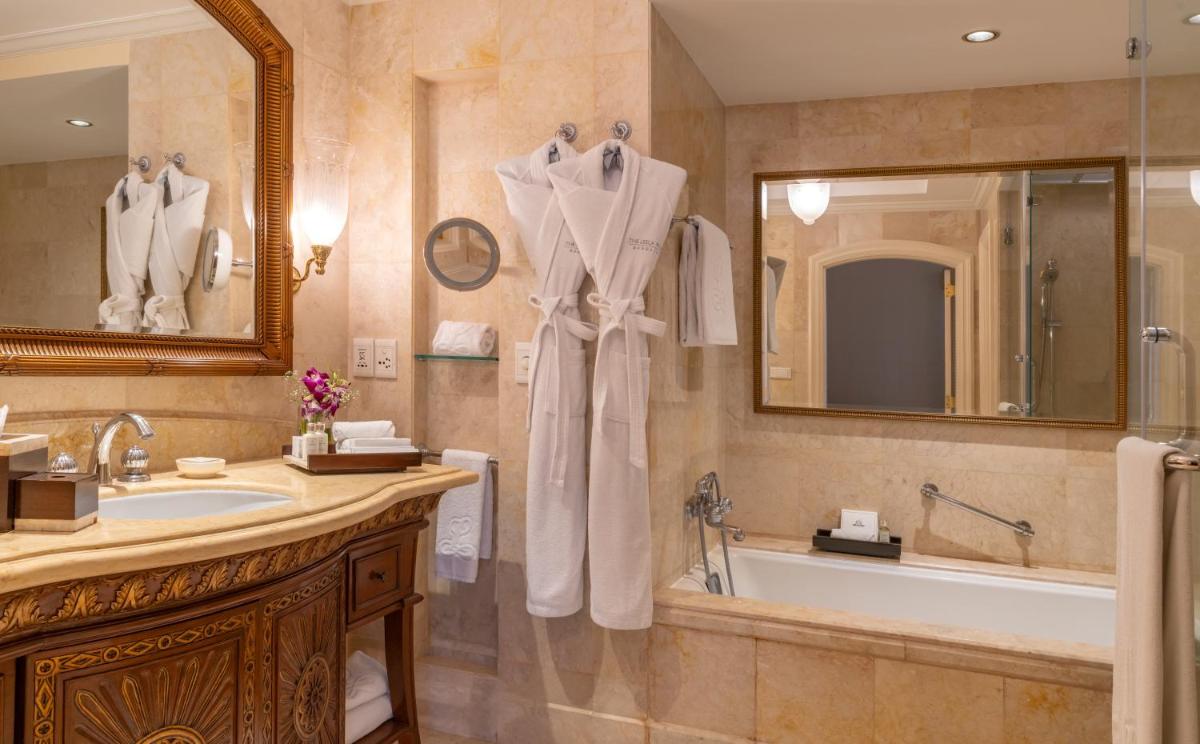 a bathroom with a tub and a sink and a bath tub at The Leela Palace Bengaluru in Bengaluru a bathroom with a tub and a sink and a bath tub at The Leela Palace Bengaluru in Bengaluru