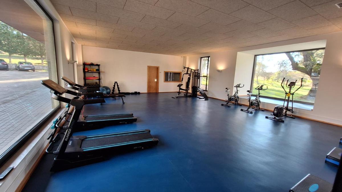 un gimnasio con varias cintas de correr y bicicletas estáticas en Hotel Balneario de Retortillo, en Retortillo 18 fotos más