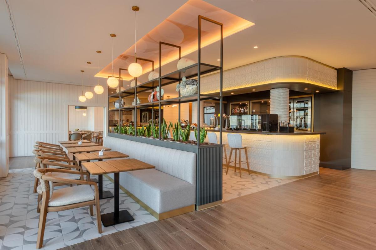 Un restaurante con mesas y sillas y un bar. en Hiru Uhinak, en Deba