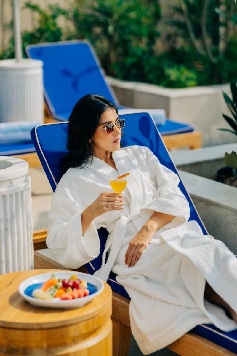 a woman sitting in a chair with a drink at Taj Amer, Jaipur in Jaipur