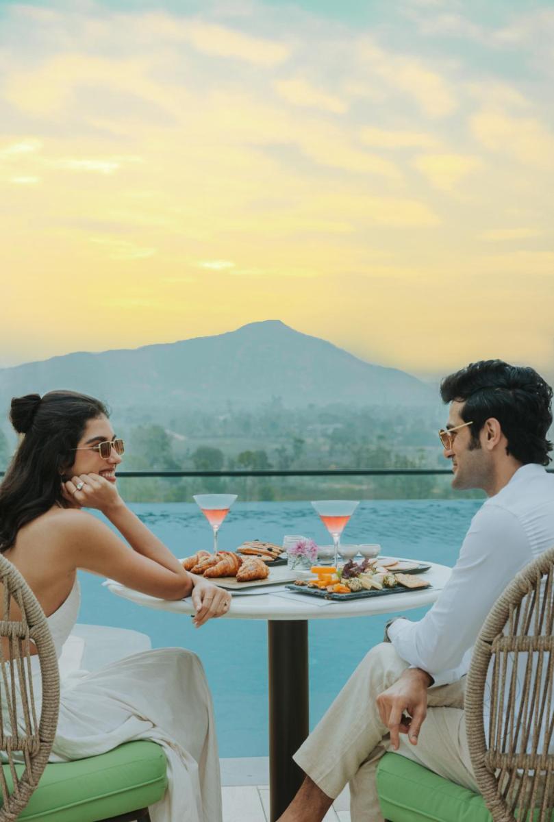 a man and a woman sitting at a table with food at Taj Amer, Jaipur in Jaipur