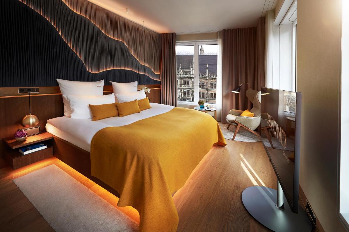 ein Hotelzimmer mit einem Bett mit einer gelben Decke in der Unterkunft BEYOND by Geisel in München ein Hotelzimmer mit einem Bett mit einer gelben Decke in der Unterkunft BEYOND by Geisel in München