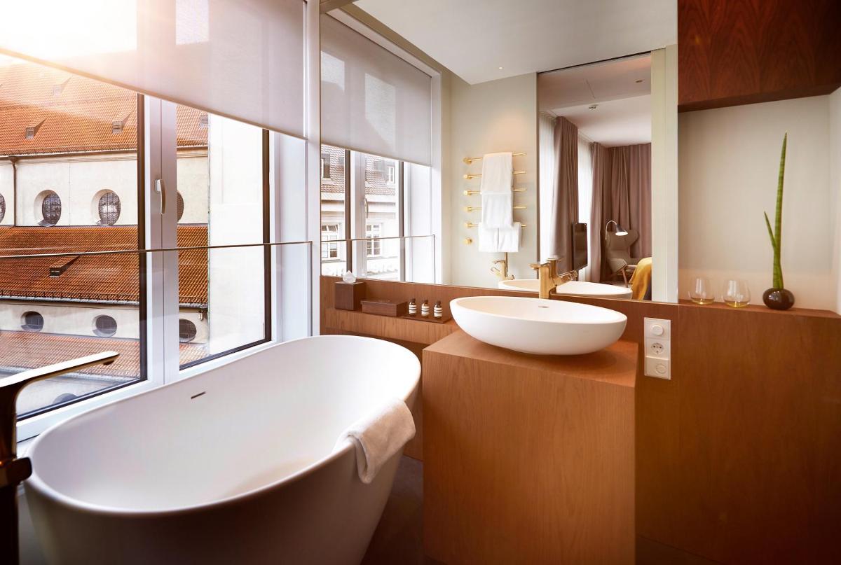 ein Badezimmer mit einer weißen Badewanne und einem Waschbecken in der Unterkunft BEYOND by Geisel in München ein Badezimmer mit einer weißen Badewanne und einem Waschbecken in der Unterkunft BEYOND by Geisel in München