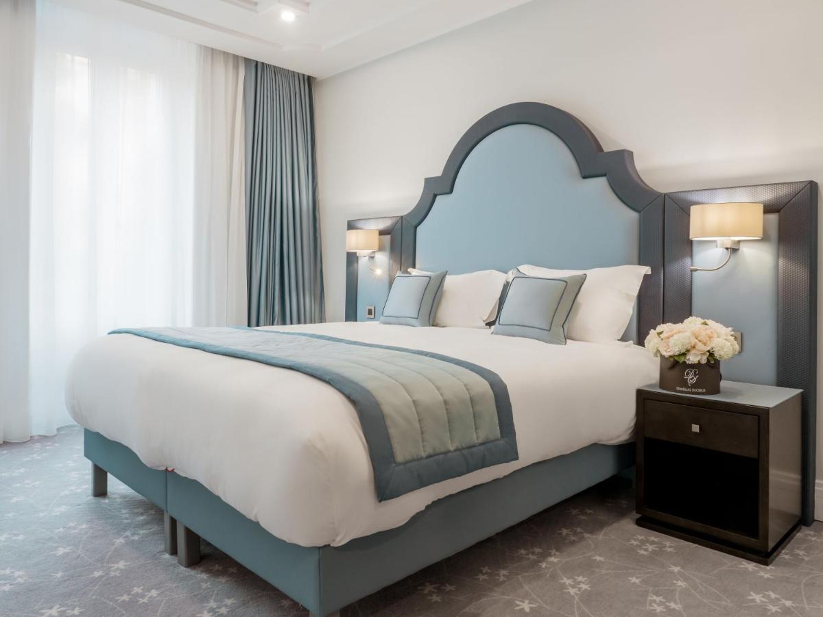 une chambre avec un grand lit avec une tête de lit bleue dans l'établissement Villa Genesis, à Menton