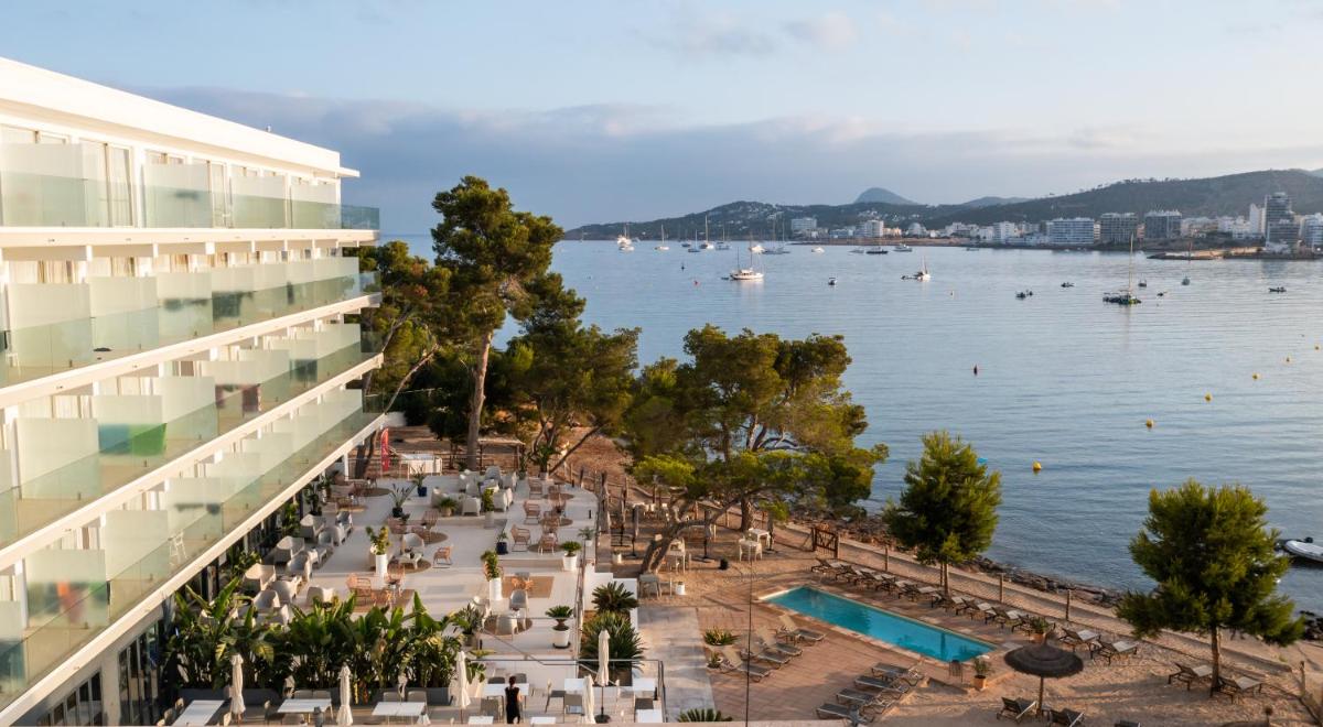 vistas a un edificio y a una masa de agua en Els Pins Resort & Spa - Emar Hotels, en Bahía de San Antonio