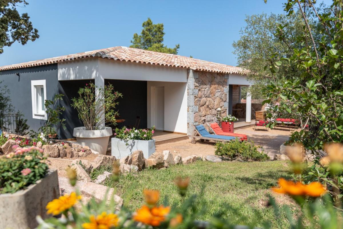 une maison en pierre avec un jardin devant dans l'établissement Le Roc E Fiori Hotel - Teritoria, à Porto-Vecchio