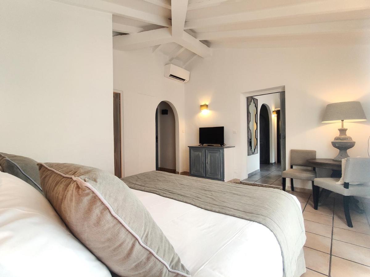 une chambre avec un lit blanc et un canapé dans l'établissement Le Roc E Fiori Hotel - Teritoria, à Porto-Vecchio