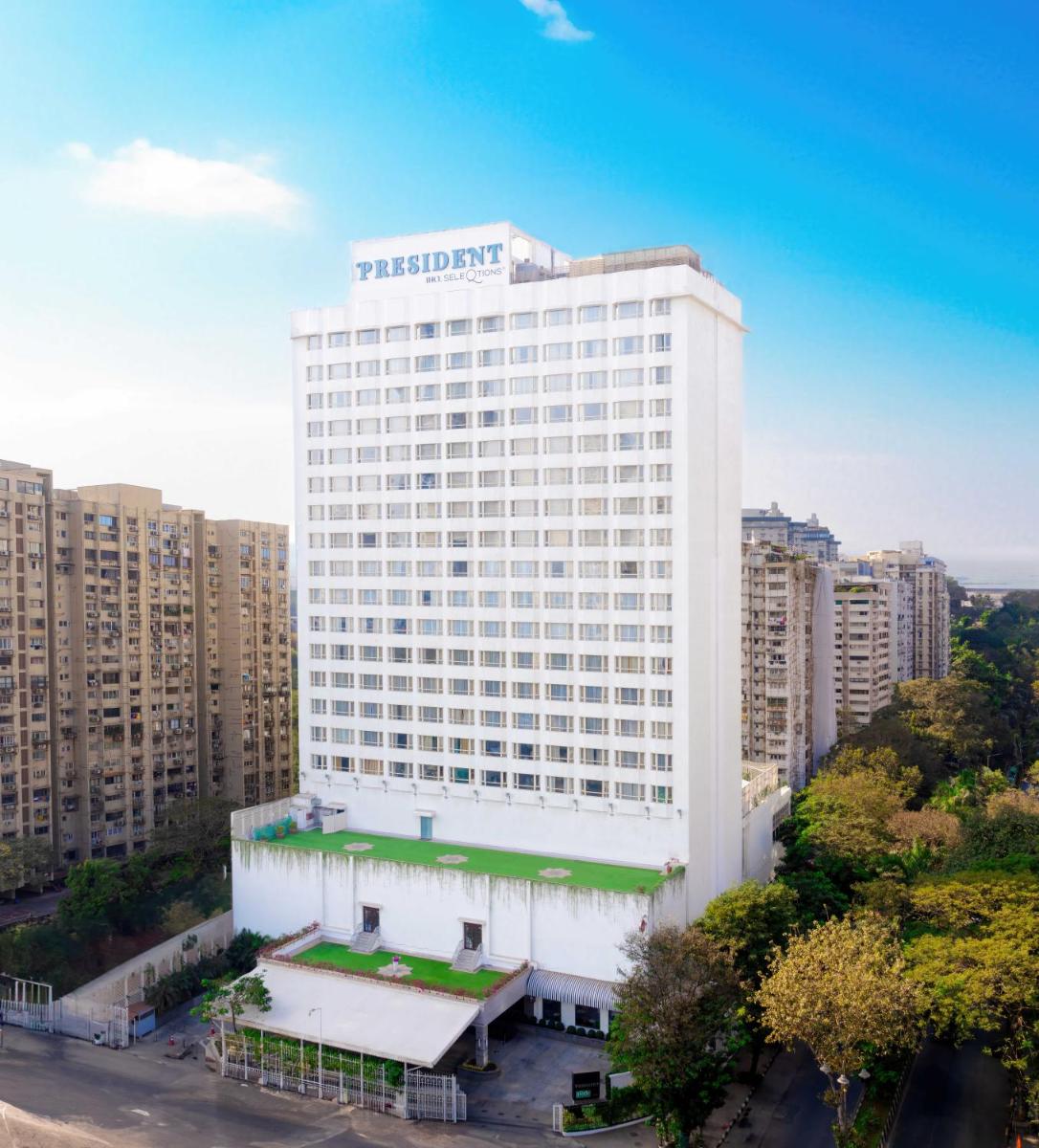 a tall white building with a sign on it at President - IHCL SeleQtions in Mumbai a tall white building with a sign on it at President - IHCL SeleQtions in Mumbai