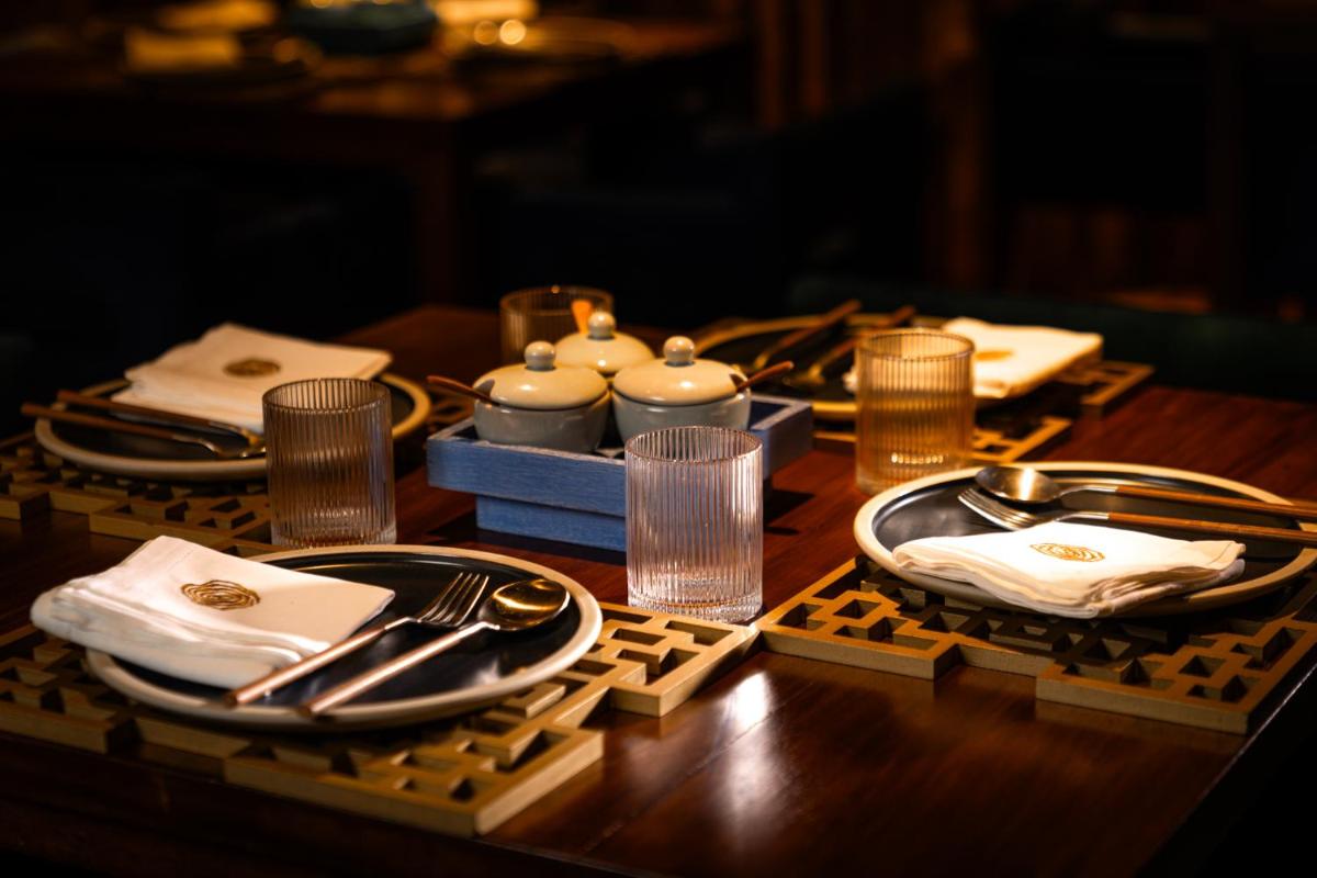 a table with plates and utensils on a table at President - IHCL SeleQtions in Mumbai