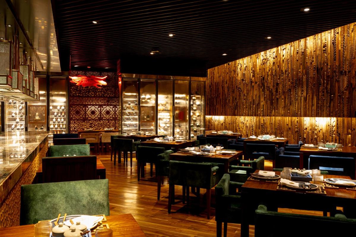 a restaurant with tables and chairs and a bar at President - IHCL SeleQtions in Mumbai