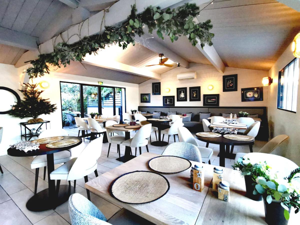 un restaurant avec des tables et des chaises dans une salle dans l'établissement Le Clos Saint-Martin Hôtel & Spa, à Saint-Martin-de-Ré